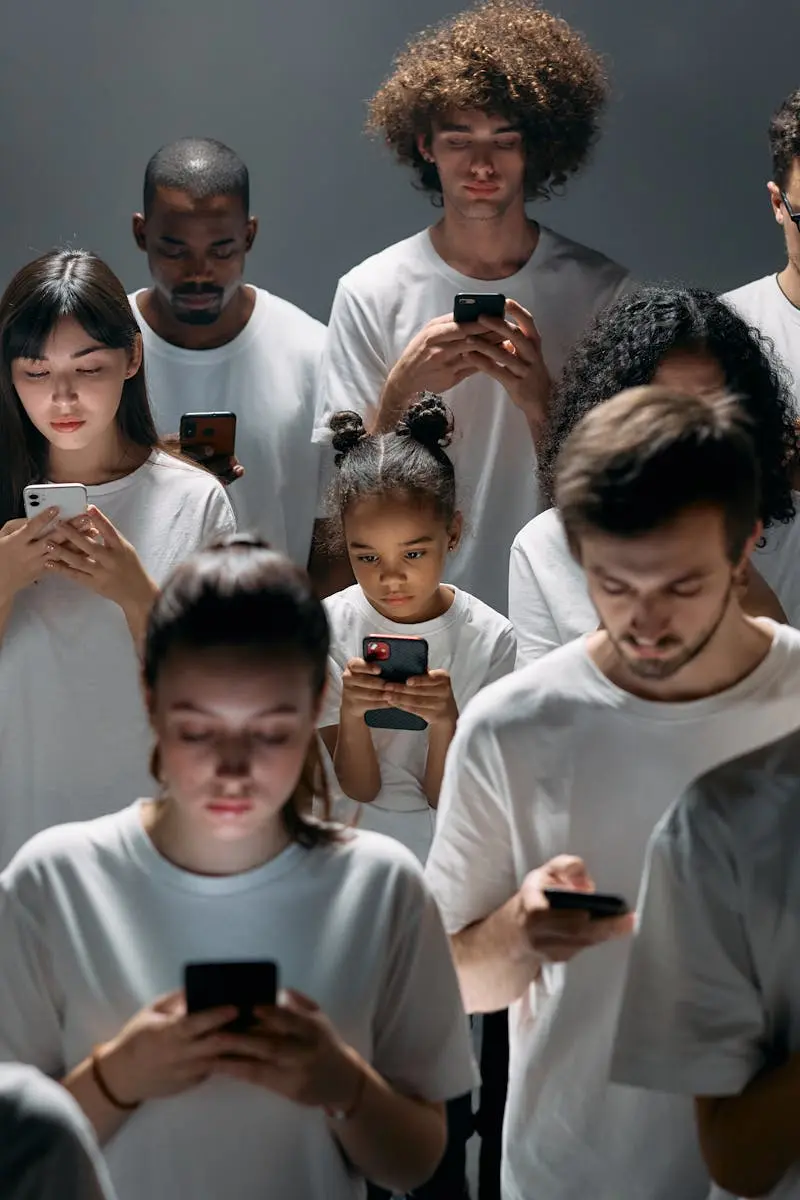 A diverse group of people focused on their smartphones, symbolizing modern technology's impact on social connection.